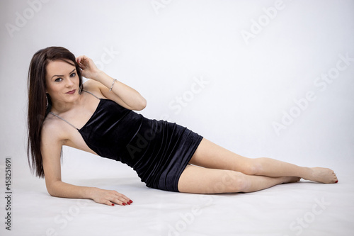 Young woman in black dress on white background