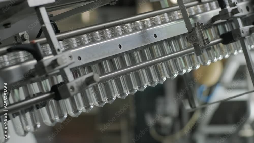 Automatic filling machine pours water into plastic PET bottles at modern beverage plant Automatic filling machine pours water into plastic PET bottles at modern beverage plant