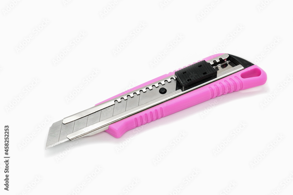 Paper cutter stationary with a pink plastic body isolated on white background. Art cutting blade with lock system. Blade sections snap-off providing the user with fresh sharp cutting points. Paper cutter stationary with a pink plastic body isolated on white background. Art cutting blade with lock system. Blade sections snap-off providing the user with fresh sharp cutting points.