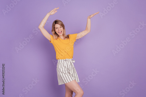 Photo of young cheerful woman happy positive smile have fun dance hip-hop dab isolated over violet color background