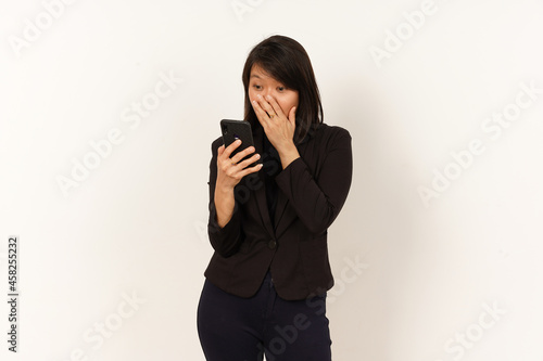 Beautiful Asian Woman Wearing black suit Surprised while using smartphone Isolated on white background