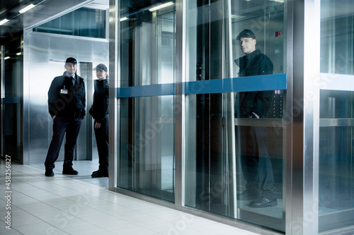 Portrait of security guards standing in corridor near elevator