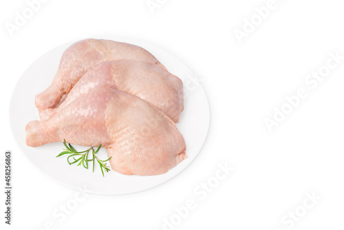 Three raw whole chicken legs on a white plate on a white isolated background. Fresh chicken legs.