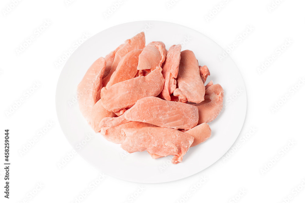 Raw frozen chicken thigh meat on a white plate on a white isolated background. Raw frozen chicken thigh meat on a white plate on a white isolated background.