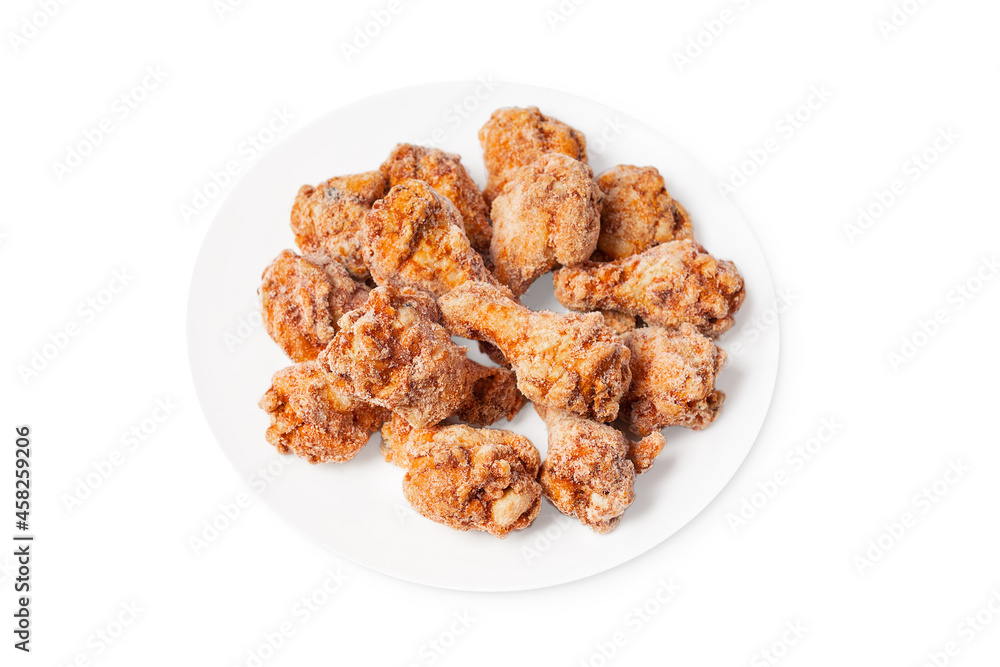 Frozen semi-cooked chicken wings on a white plate on a white background.Fast food, convenience food.