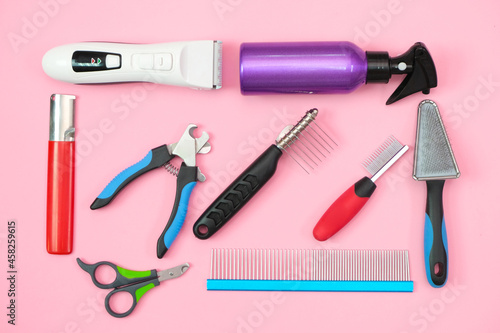 pet care and grooming tools on a pink background. photo