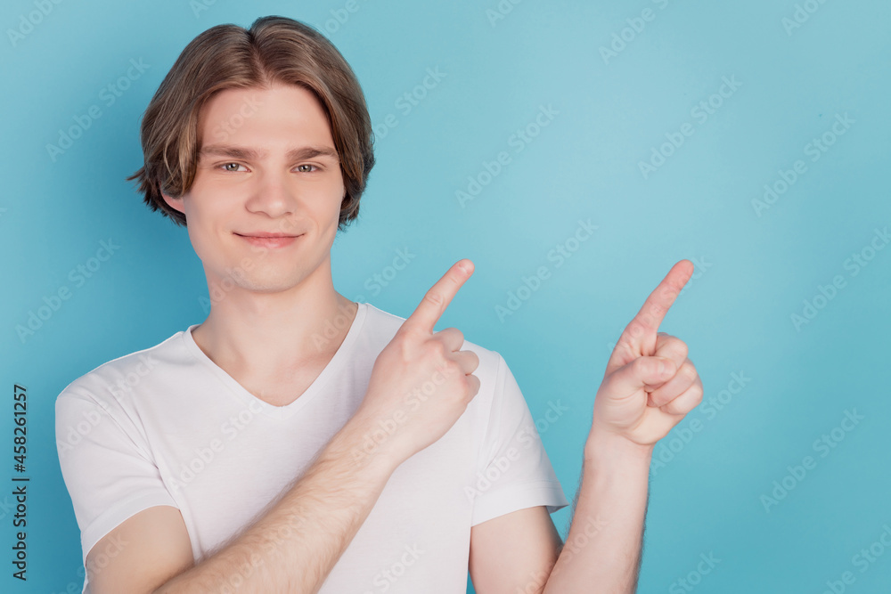 Happy guy isolated showing pointing promotion with index finger blue empty space background Happy guy isolated showing pointing promotion with index finger blue empty space background