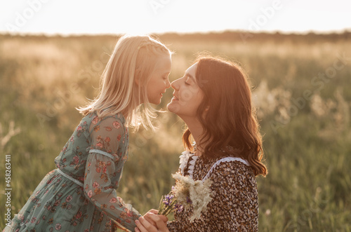 Older and younger sisters walk together in nature in the summer. sister hugs and soothes
