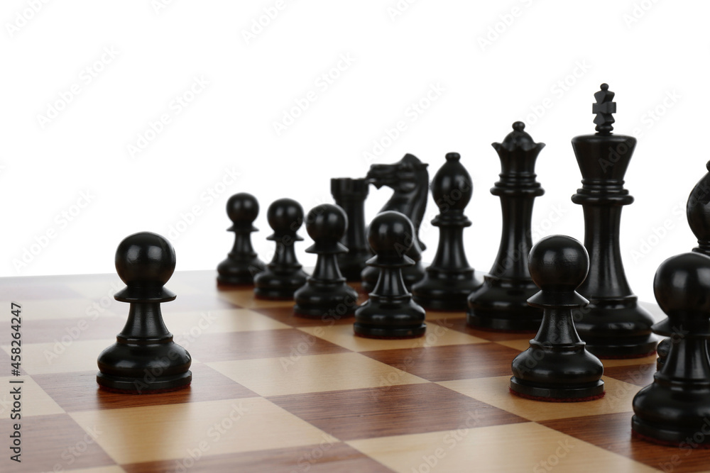Black pawn in front of other chess pieces on wooden board against white background Black pawn in front of other chess pieces on wooden board against white background