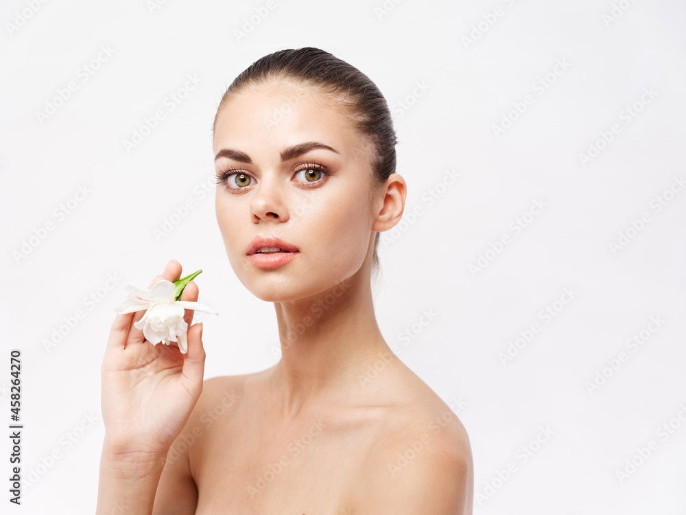woman with a flower in her hands naked shoulders cosmetics attractive look woman with a flower in her hands naked shoulders cosmetics attractive look