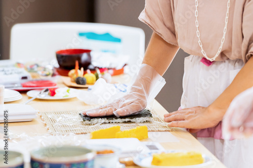 料理教室で巻き寿司を作る女性の手元