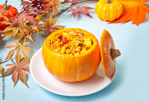 Fresh cooked pumpkin soup served in a pumpkin. Autumn warm and cozy food.