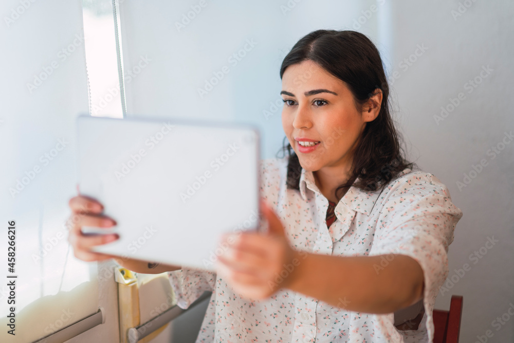 Chica joven risueña guapa interactuando con una tablet Chica joven risueña guapa interactuando con una tablet