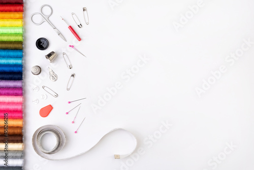 Colorful threads and sewing accessories on a white background. Sewing background