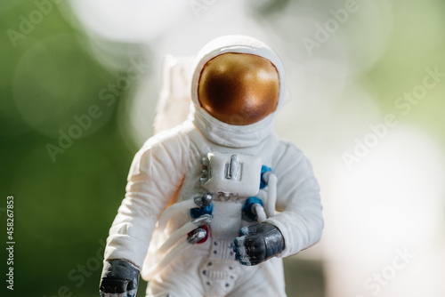 toy astronaut standing on ground. Spaceman figure Travel concept environmental protection. Astronaut exploring new planet. Searching for new home for humanity. Concept about science and nature
