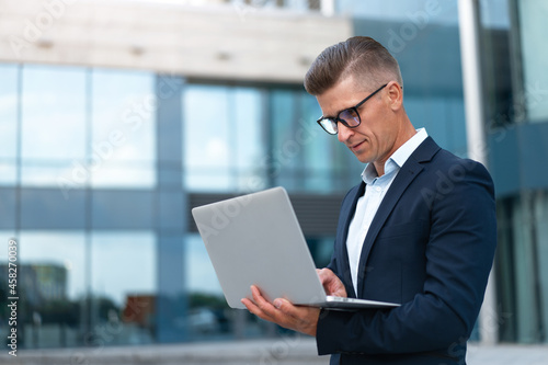 Business. Businessman Using Laptop Outdoor Summer Day © Andrii