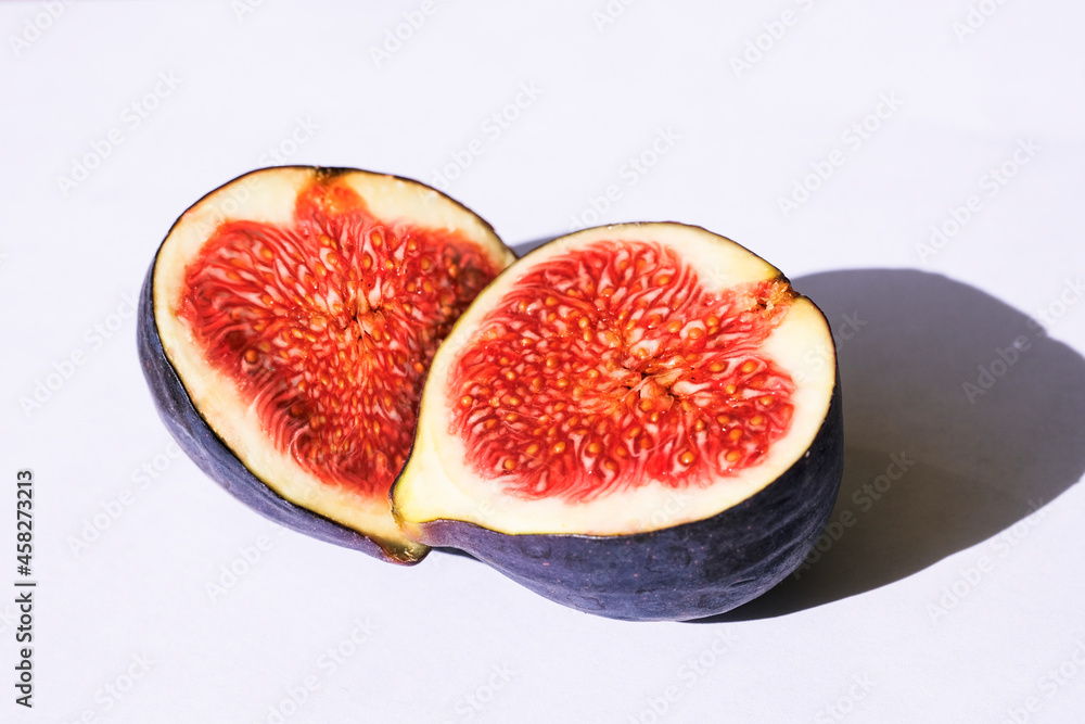 Fresh sliced ripe figs on white. Halves of fruit Fresh sliced ripe figs on white. Halves of fruit