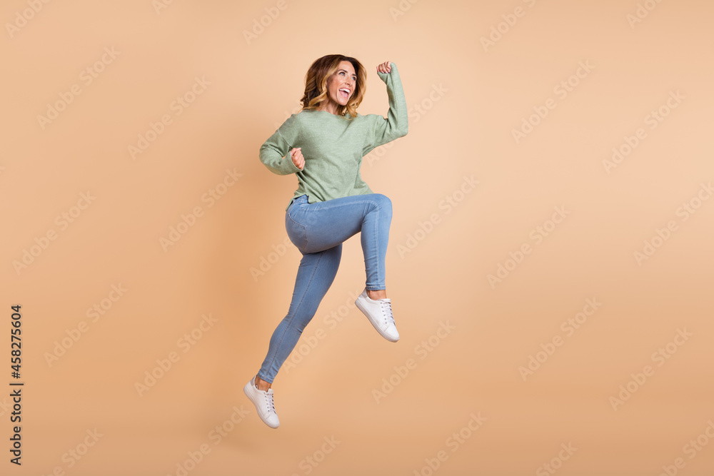 Full length body size back view photo woman jumping gesturing like winner overjoyed isolated pastel beige color background