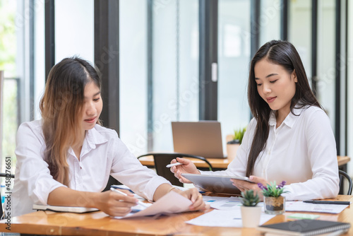 Young Asian businesswoman have a meeting to discuss work using a document tablet graph at the office