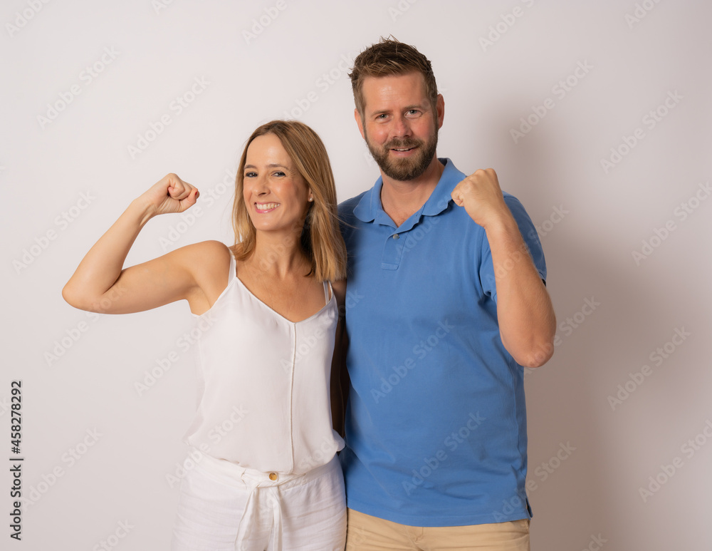 Portrait of cheerful people man and woman in basic clothing smiling and clenching fists like winners or happy people isolated over white background Portrait of cheerful people man and woman in basic clothing smiling and clenching fists like winners or happy people isolated over white background