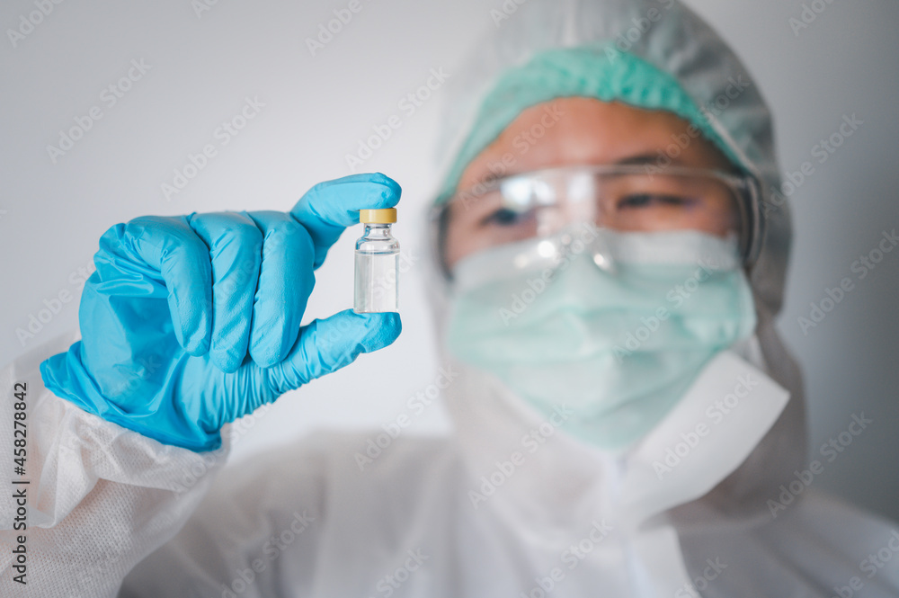 doctor or scientist holds a liquid vaccine bottle for the treatment of viral diseases.. doctor or scientist holds a liquid vaccine bottle for the treatment of viral diseases..