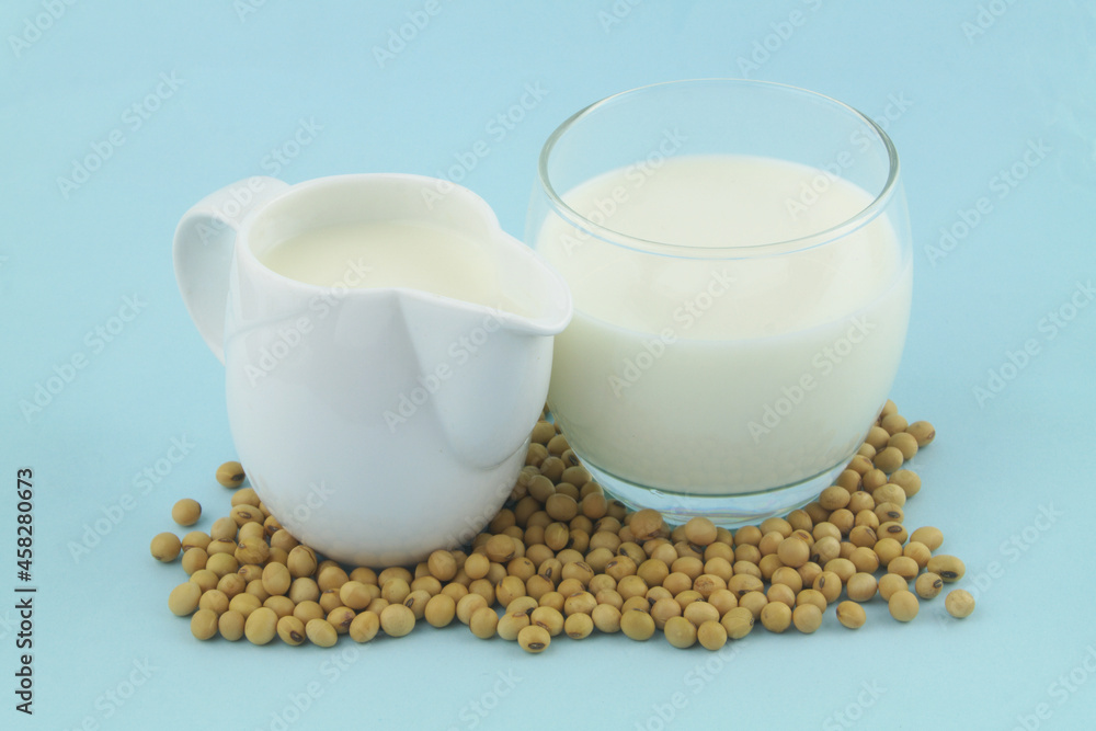 Soy milk with soy beans on blue background close up Soy milk with soy beans on blue background close up