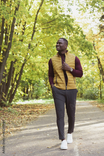 African american student walking in the park in autumn season