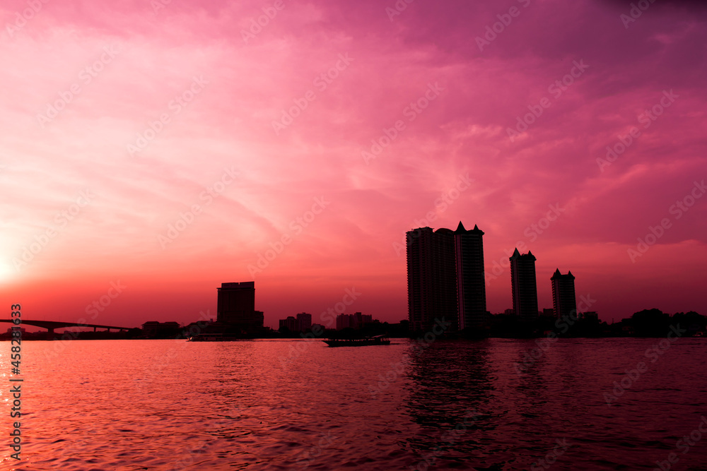Silhouette of waterfront city and red sky