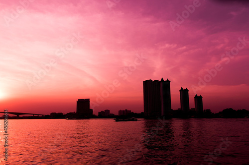 Silhouette of waterfront city and red sky