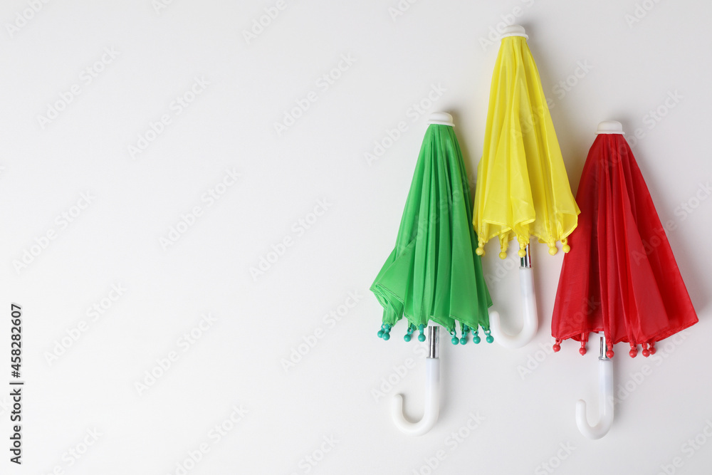 Small color umbrellas on white background, top view. Space for text Small color umbrellas on white background, top view. Space for text