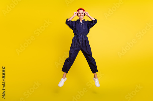 Full length body size view of attractive cheerful girl jumping having fun rest isolated over bright yellow color background