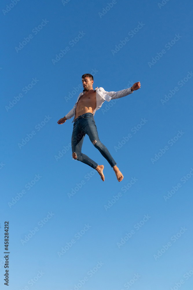 Active dancer jumping against blue sky Active dancer jumping against blue sky
