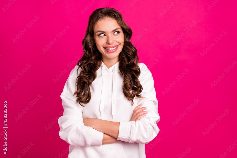 Photo of young attractive girl happy positive smile crossed hands curious look empty space isolated over pink color background Photo of young attractive girl happy positive smile crossed hands curious look empty space isolated over pink color background