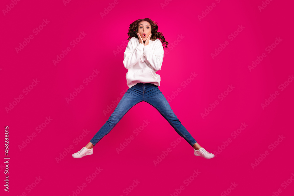 Photo of surprised funny lady jump hands cheeks omg face wear white hoodie isolated pink color background