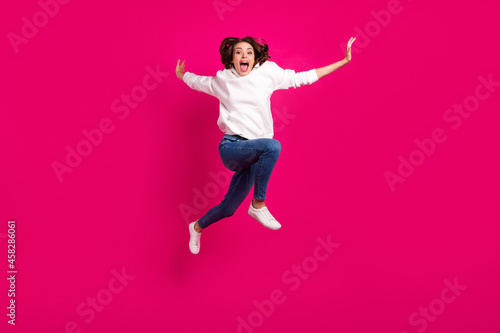 Full body photo of young excited girl amazed shocked surprised jump yell isolated over pink color background