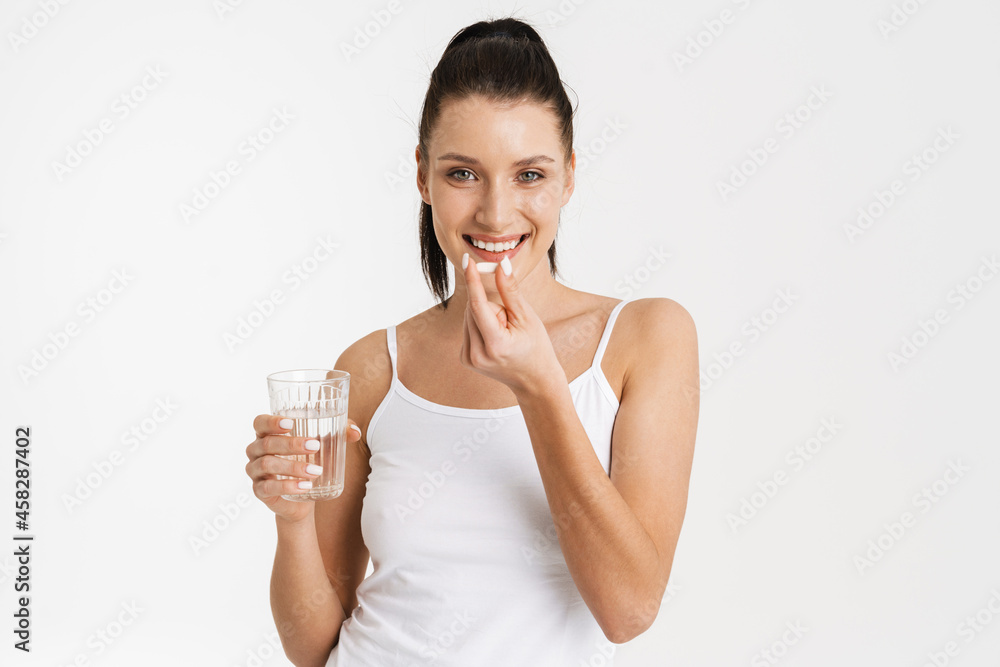 European woman wearing underwear smiling while taking vitamins European woman wearing underwear smiling while taking vitamins