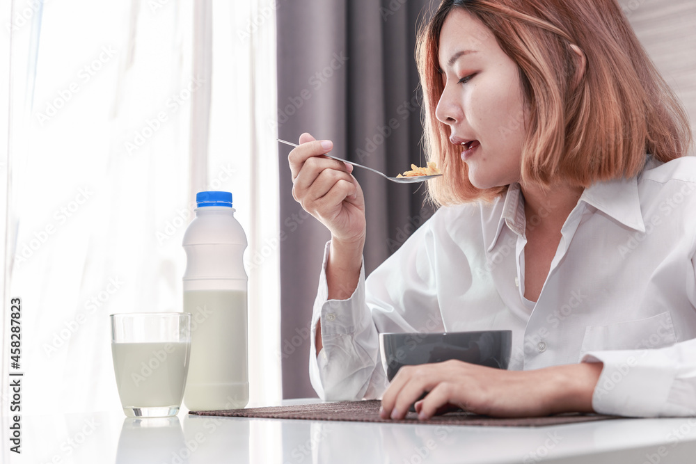 Young Asian woman having tasty healthy breakfast. Young Asian woman having tasty healthy breakfast.