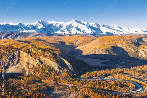 Top view of the Kurai Steppe, the Chuya River Valley and the snow-covered North Chuya Ridge in autumn at sunset. Altai Republic, Russia
