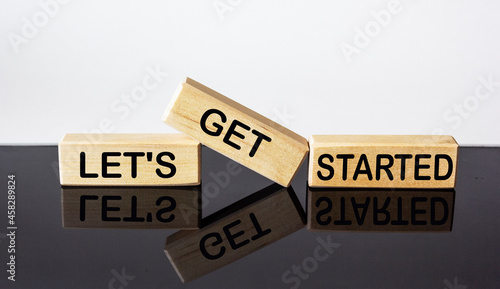 let's get started text on wood block and black and white background. business concept