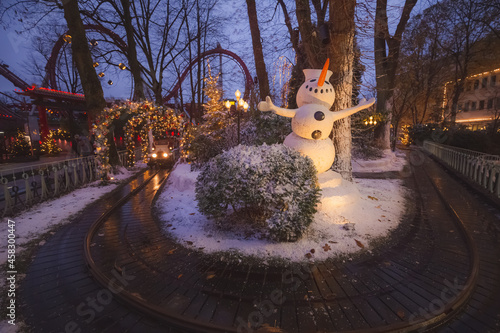 Canvas Print Decorative Christmas lights and winter decorations at Tivoli Gardens theme park and snowman around a toy train track in Copenhagen, Denmark