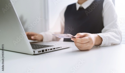 Woman holding credit card and using laptop computer for Internet online e-commerce shopping spending money Online shopping laptop technology concept . Online shopping pay by credit card concept