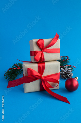 Christmas gifts with tied red bow on the blue background. Close-up.