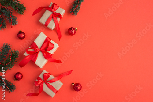 Christmas gifts with tiew red bow on the red background. Copy space. photo