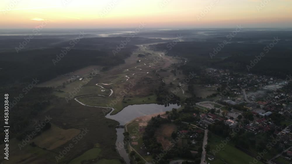 Sunrise over the river and the town of Suprasl.View from the drone over the river ,the lagoon,the surrounding fields,meadows and forests. Sunrise over the river and the town of Suprasl.View from the drone over the river ,the lagoon,the surrounding fields,meadows and forests.