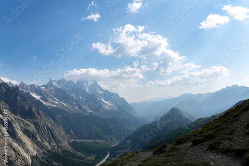 Panoramic view of silhouette mountain scenery with mountains in the background and meadow, grass on a nice, sunny day