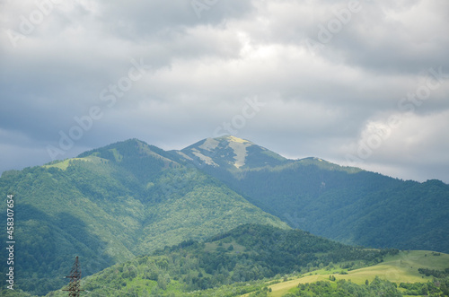 View to peak of mountain Strymba from Kolochava village against the sky with clouds. Carpathian Mountains, Ukraine