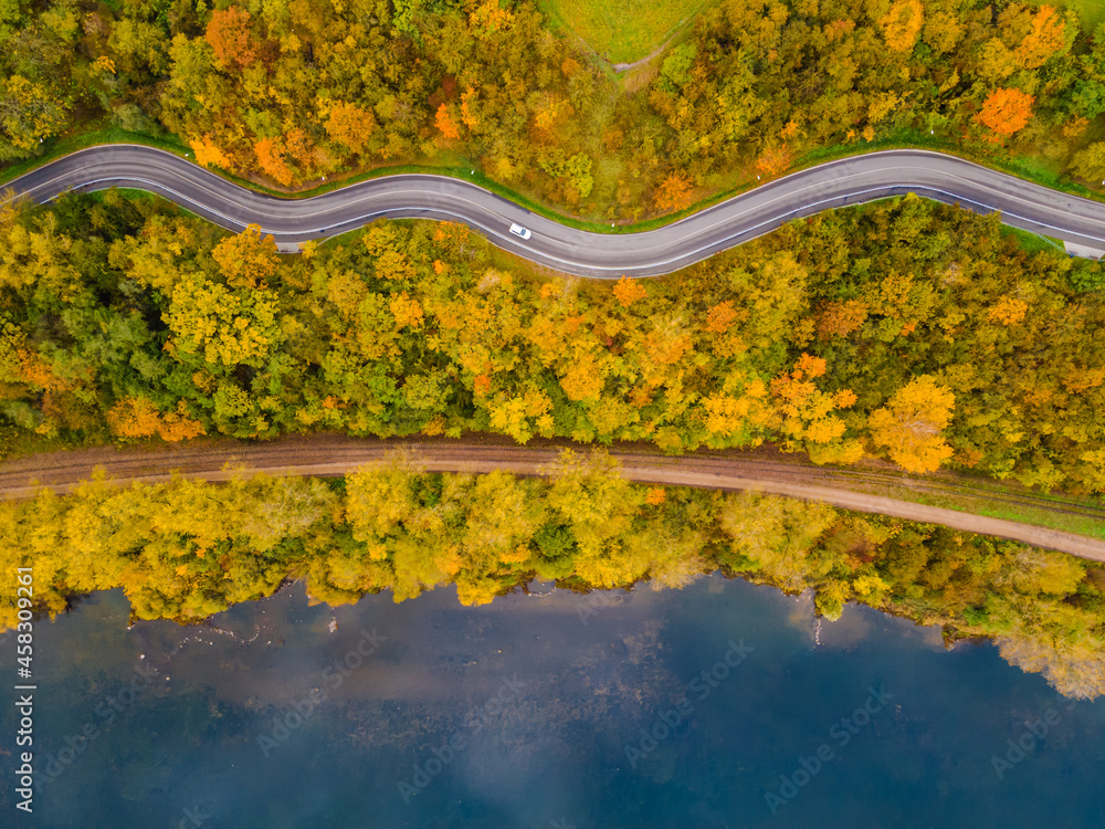 Aerial scenery view of winding road and railway beside in autumn fall in Kaunas, Lithuania