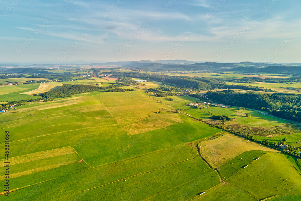 Aerial view of green agricultural fields and mountains. Beautiful nature landscape. Countryside village
