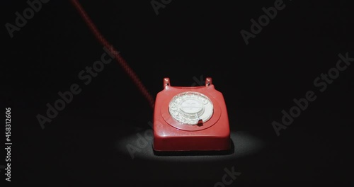 Hand picking up and hanging red vintage telephone photo