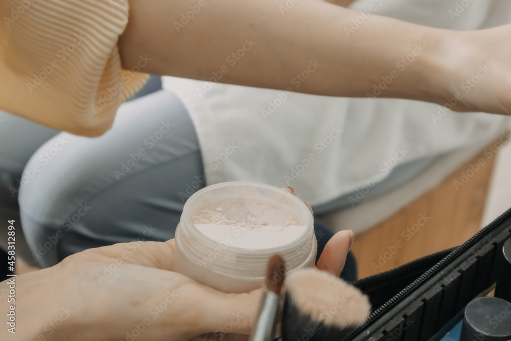 Naklejka premium The makeup artist is using makeup tools applying to the client.